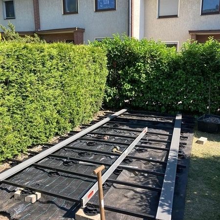 Ein kleiner Garten einer Hecke und ein Pool, der aufgebaut wird